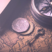 coins, a key, and a compass on a map, denoting travel.