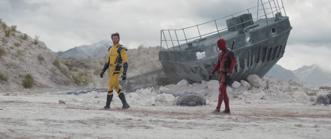 Image of Wolverine walking away from Deadpool in a barren landscape. There is part of a ship behind them.